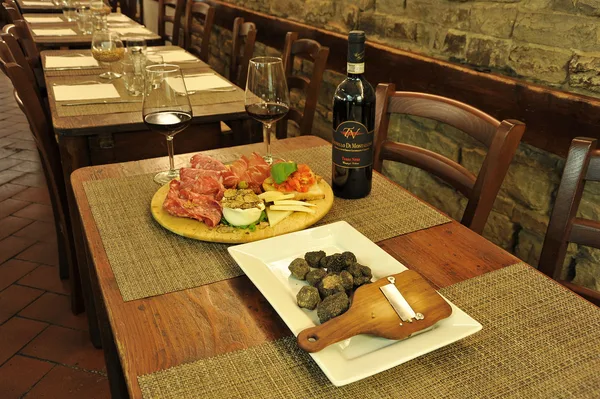 Tuscan antipasti and red wine on a table at Il Cantinone